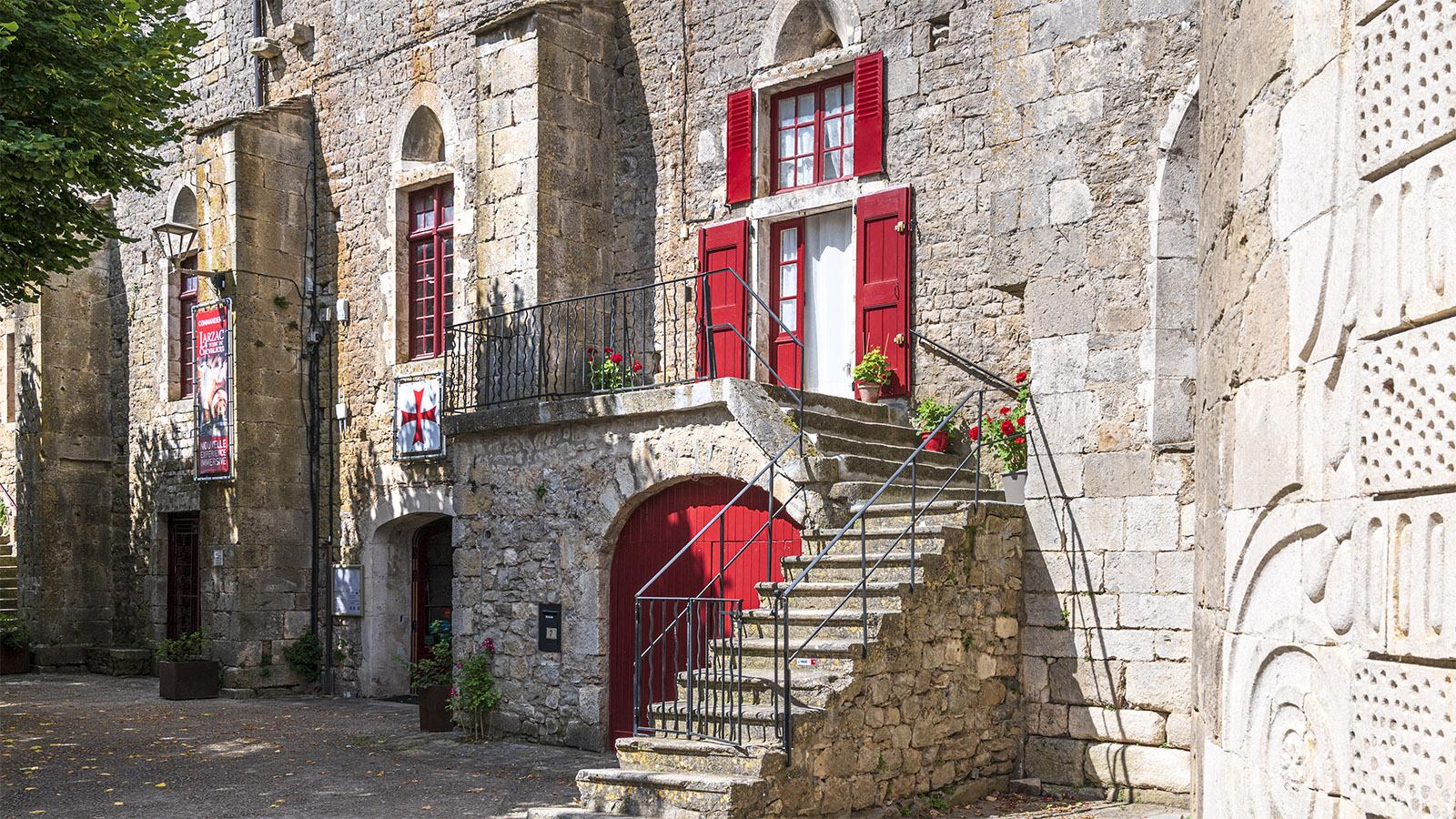 Rote Fenster setzen farbige Akzente auf den Naturstein und sorgen für eine ganz besondere Stimmung in Sainte-Eulalie-de-Cernon. Foto: Hilke Maunder