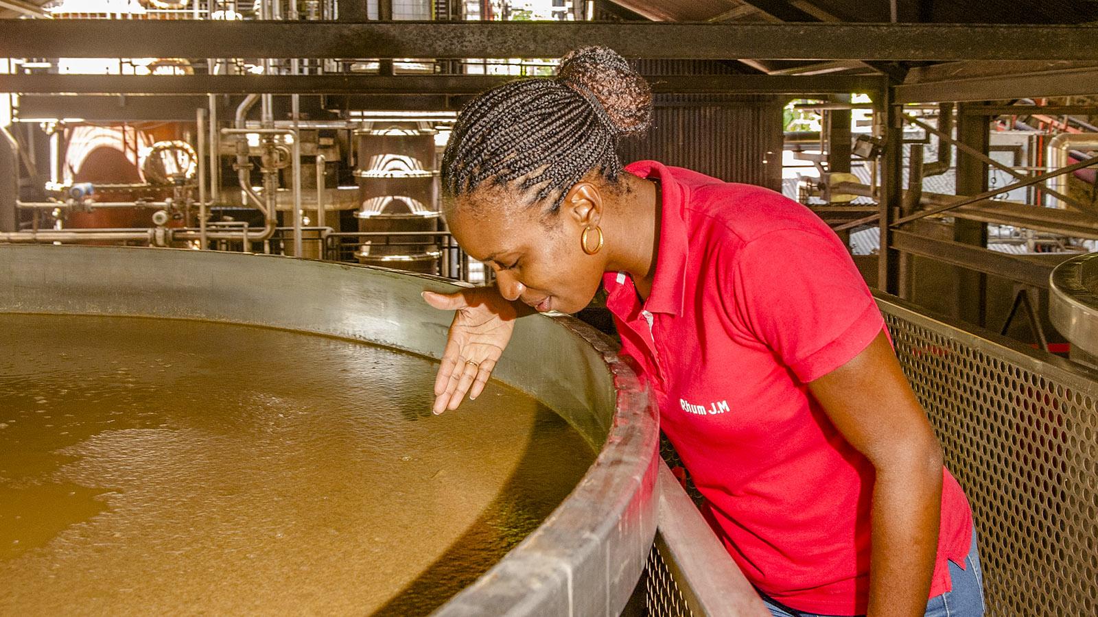 Rum-Herstellung auf Martinique: Aurelie Bapté erklärt die Fermentation, die in riesigen Kesseln erfolgt. Foto: Hilke Maunder
