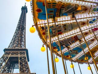 Vor dem Eiffelturm dreht sich ein Karussell. Foto: Hilke Maunder