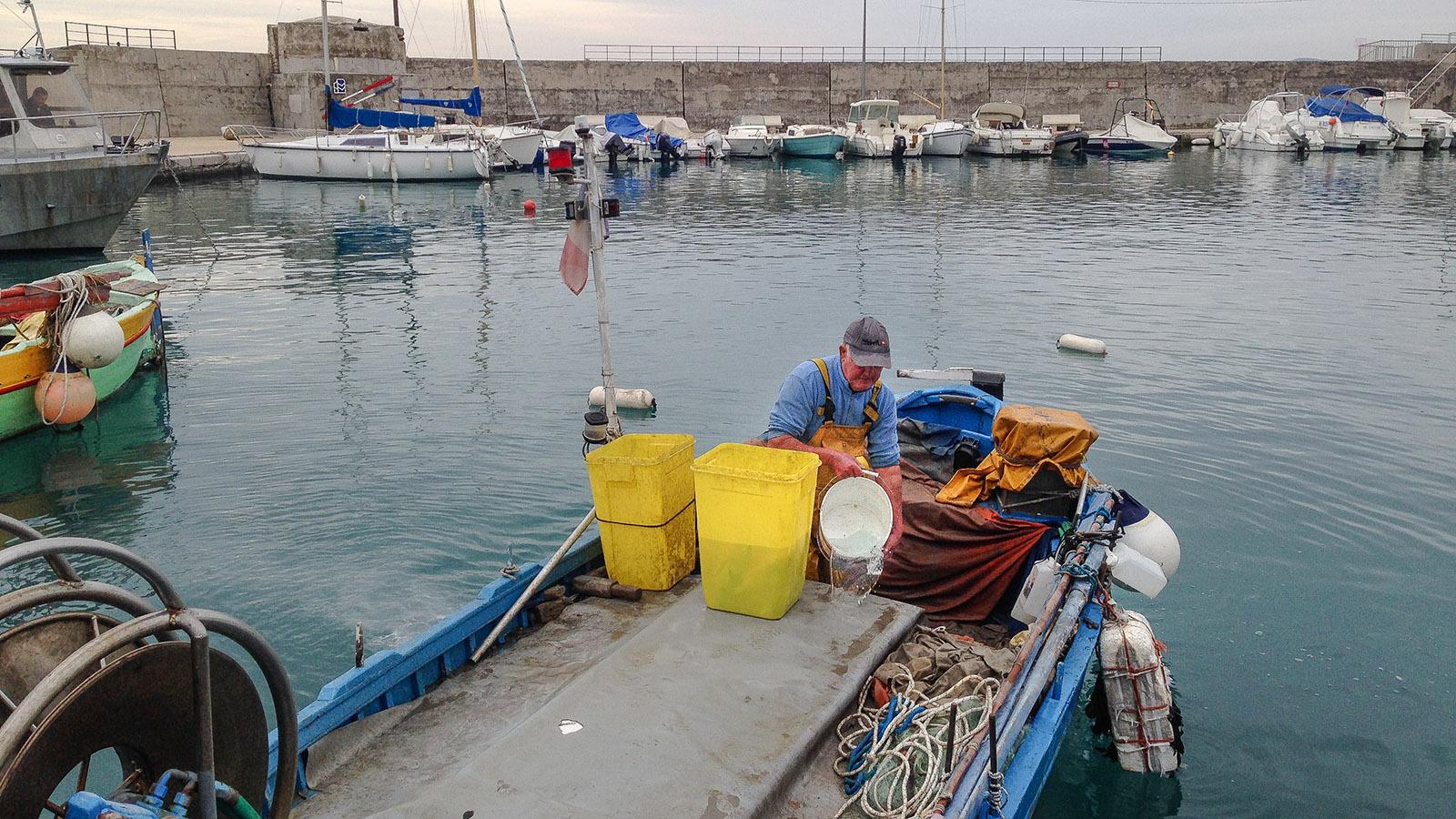 Cages-sur-Mer: Ein Fischer säubert sein Boot. Foto. Hilke Maunder