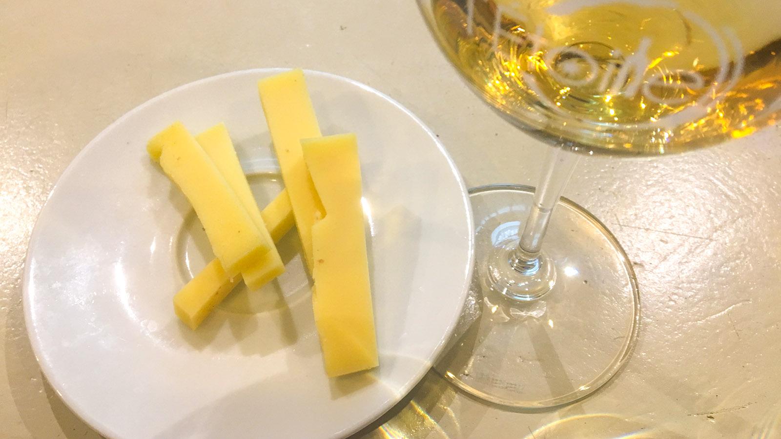 Im Glas ein <em>Vin Jaune</em>, auf dem Teller Comté-Käse: typische Genussmomente aus dem Jura. Foto: Hilke Maunder