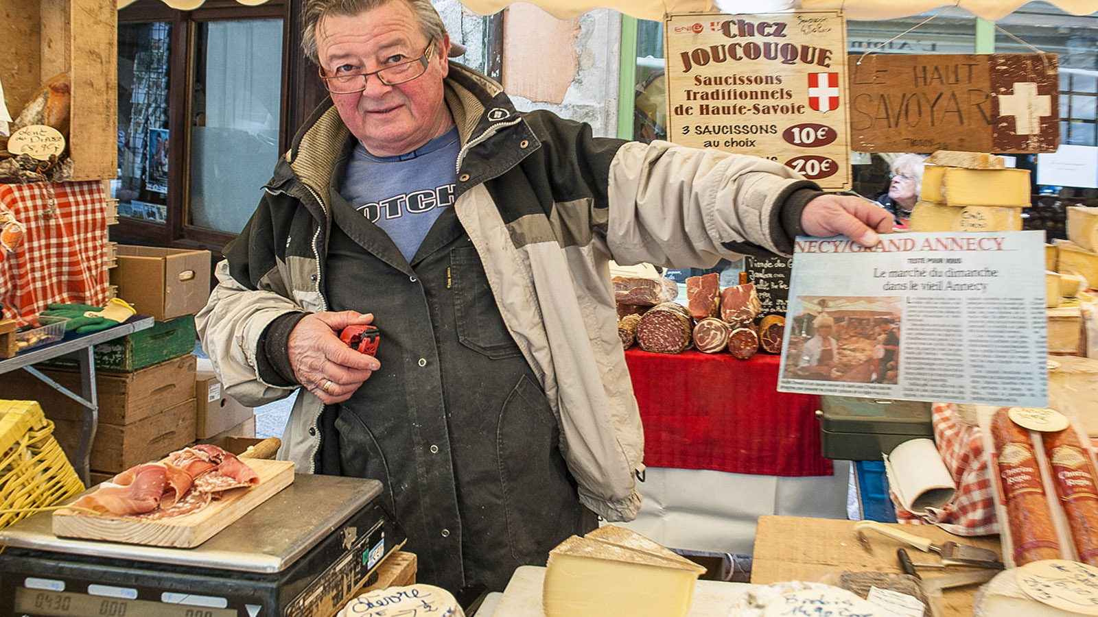 Stolz auf einen Zeitungsartikel: Käseverkäufer auf dem Sonntagsmarkt von Annecy. Foto: Hilke Maunder