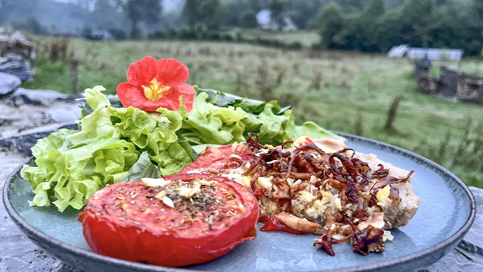 Komponiert aus den Zutaten des Gartens und des nahen Waldes: Pilz-Tarte mit gründem Salat, gewürzter Tomate und einer Kapuzinerkresse-Blüte als Deko. Foto: Hilke Maunder