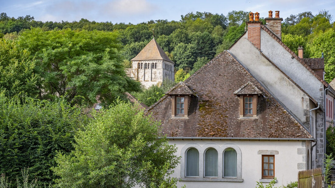 Der Blick über die dunklen Tondächer des Dorfes hin zum Kirchturm der Abteikirche. Foto: Hilke Maunder